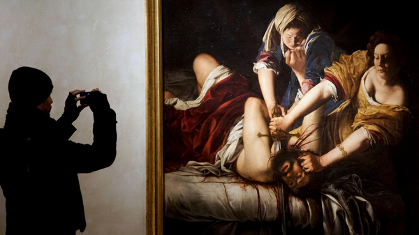 A visitor takes a photo of Judith Slaying Holofernes by Italian 17th century artist Artemisia Gentileschi, on display at Rome